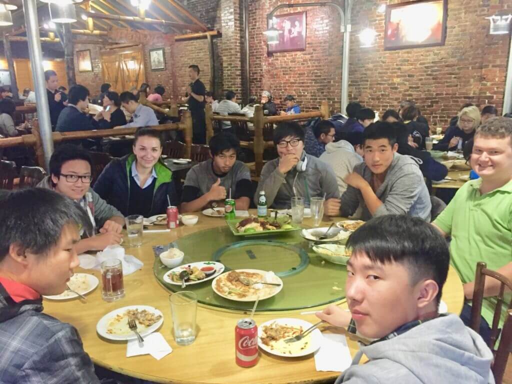 a group of cogito international students sitting together and enjoying a thanksgiving meal at a Boston restaurant