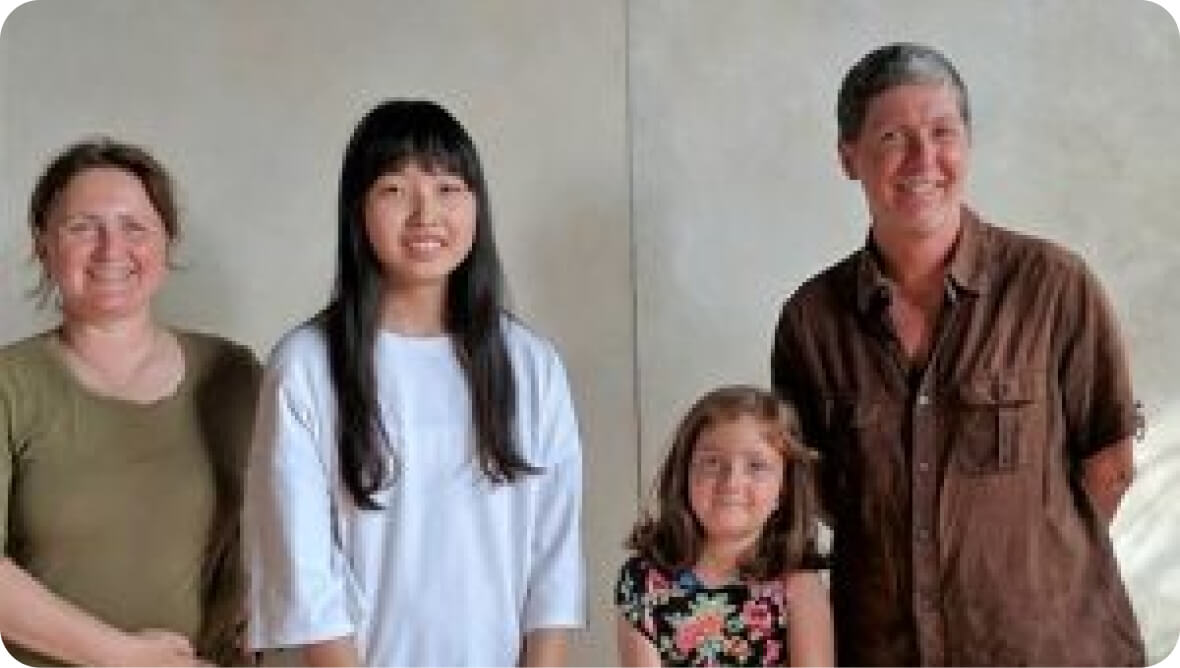 one of our international students smiling with her host family, her option of how to spend her school break