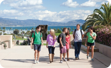a group of international university students walking near the beach and having a conversation about their time in the USA