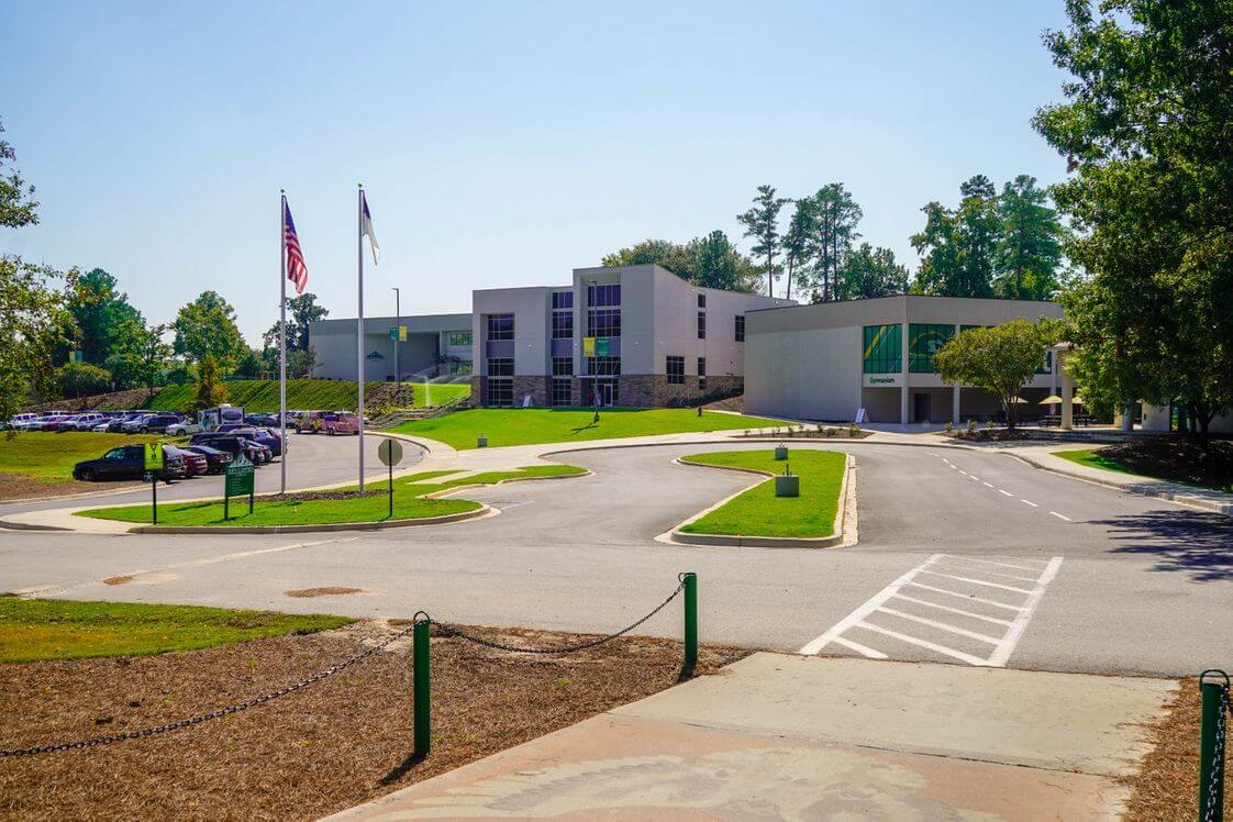 The parking lot and main acaedmic building of one of the best high schools in South Carolina, nested near a large forest