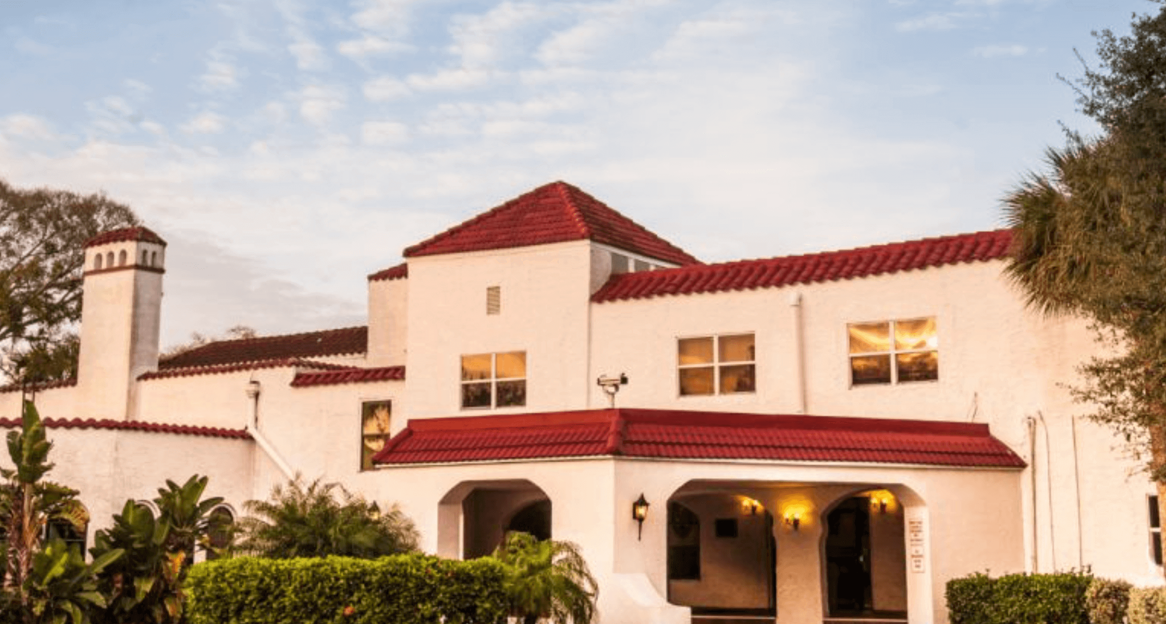 A mediterranean styled school building, a common architecutral style in Florida, glows in the warm sunset